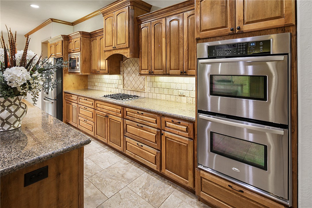 4662 Hidden Springs Way College Station, TX 77845 - Photo 12 of 48 a kitchen with stainless steel appliances granite countertop a stove a microwave and a sink