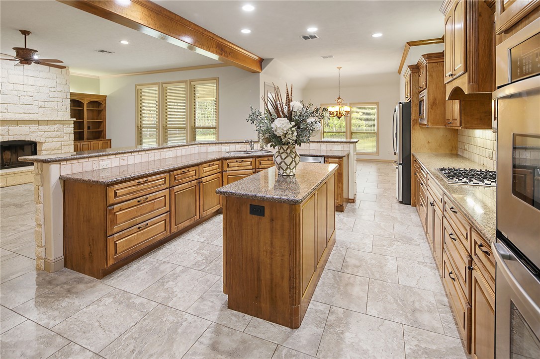 4662 Hidden Springs Way College Station, TX 77845 - Photo 13 of 48 a large kitchen with stainless steel appliances granite countertop a large counter top a stove and a sink