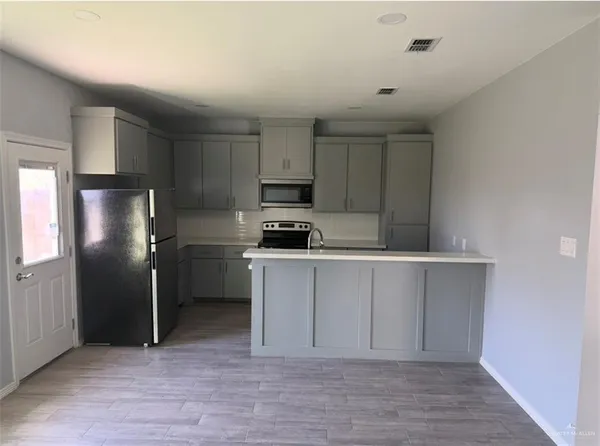 a kitchen with cabinets stainless steel appliances and a counter space