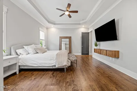 a bedroom with a large bed and a chandelier
