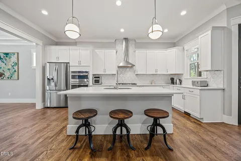 a kitchen with stainless steel appliances white cabinets sink and stove