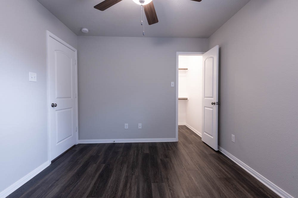 1001 Rootstock Rd. Brenham, TX 77833 - Photo 14 of 28 an empty room with wooden floor cabinet and windows