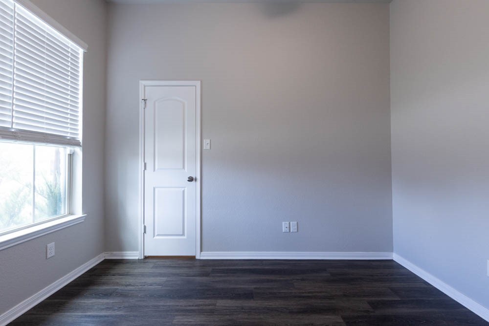 1001 Rootstock Rd. Brenham, TX 77833 - Photo 16 of 28 a view of an empty room with wooden floor and a window