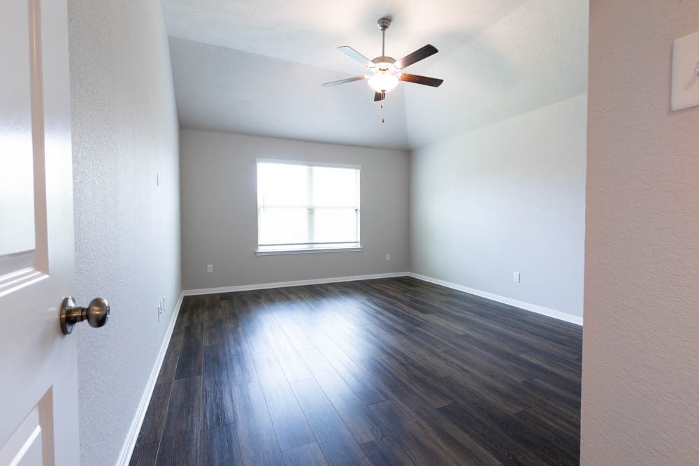 1001 Rootstock Rd. Brenham, TX 77833 - Photo 19 of 28 an empty room with wooden floor and windows