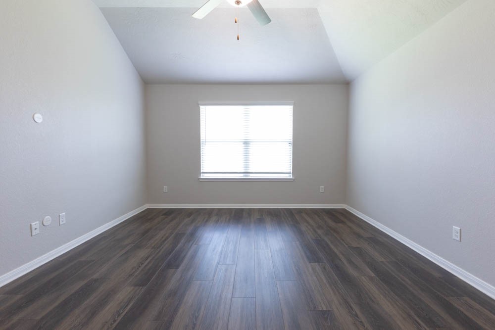 1001 Rootstock Rd. Brenham, TX 77833 - Photo 20 of 28 an empty room with wooden floor and windows