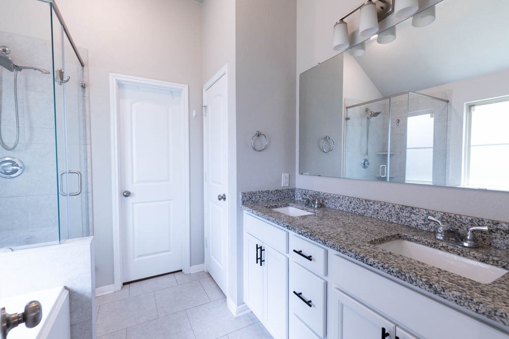 1001 Rootstock Rd. Brenham, TX 77833 - Photo 21 of 28 a spacious bathroom with a granite countertop sink and a mirror