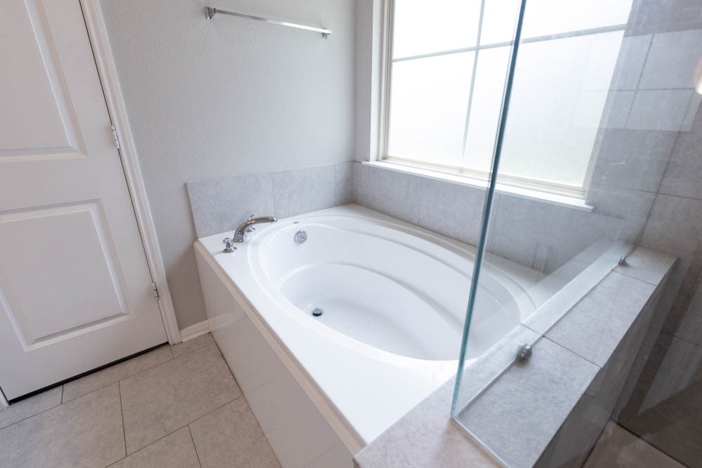1001 Rootstock Rd. Brenham, TX 77833 - Photo 22 of 28 a bathroom with a bathtub and window