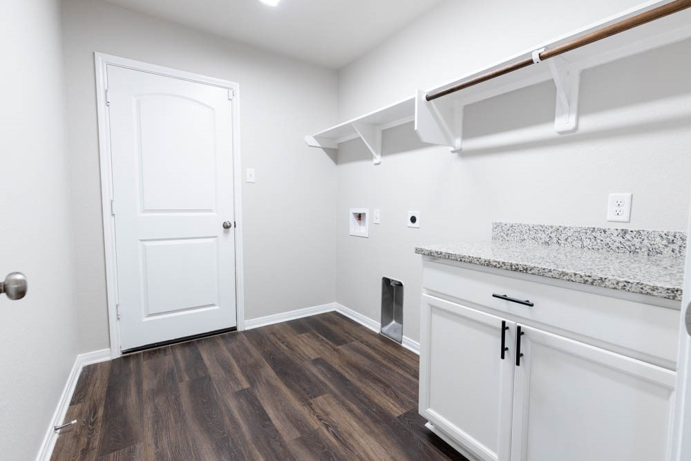 1001 Rootstock Rd. Brenham, TX 77833 - Photo 25 of 28 a view of a hallway with wooden floor and cabinet