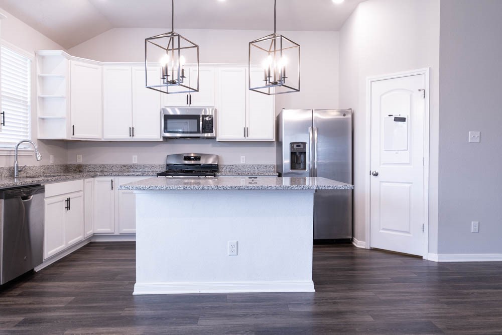 1001 Rootstock Rd. Brenham, TX 77833 - Photo 10 of 28 a kitchen with stainless steel appliances granite countertop a refrigerator a sink dishwasher a stove and white cabinets with wooden floor