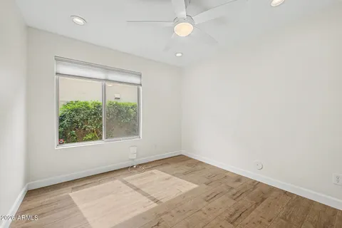 an empty room with a window and a ceiling fan