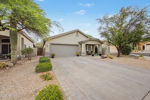 a front view of a house with a yard and potted plants