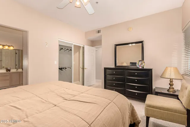 a bedroom with a bed and a mirror on dresser