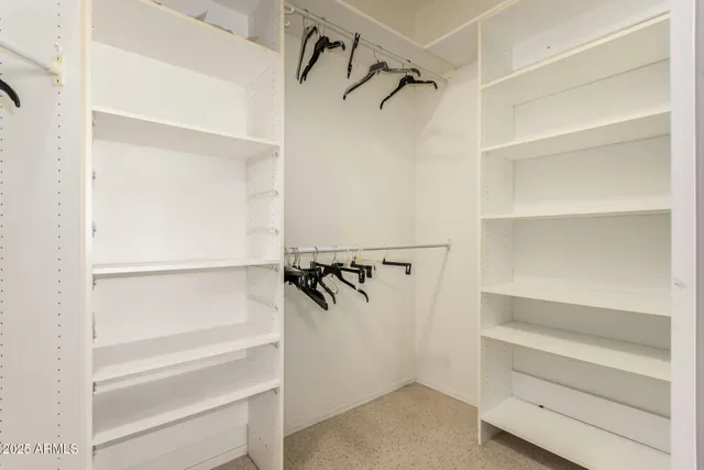 a view of walk in closet with empty racks