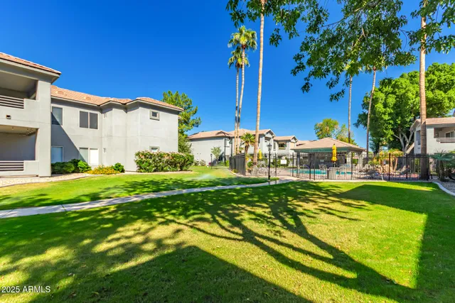 a view of an house with backyard space and balcony