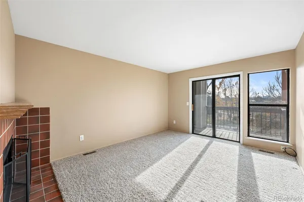 a view of a livingroom with an empty space and a fireplace