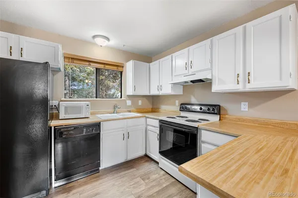 a kitchen with cabinets appliances a sink and a window