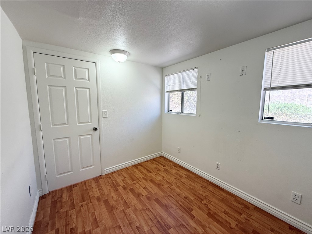 616 Greenway Road Henderson, NV 89002 - Photo 12 of 32 A quiet secondary bedroom with a wood-look floor, ready for personalization.