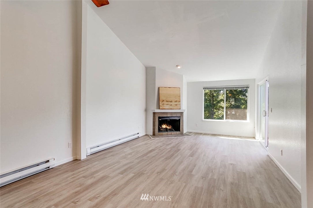 2515 Northeast 4th Street, Unit 531 Renton, WA 98056 - Photo 11 of 28 an empty room with wooden floor fireplace and windows