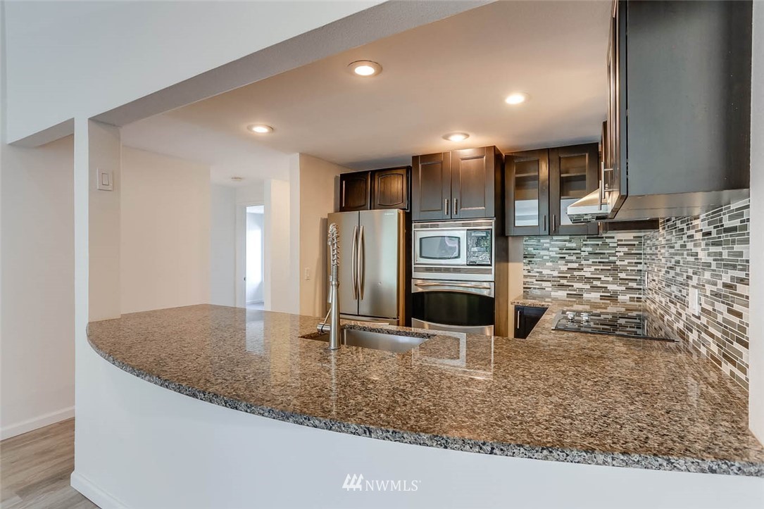 2515 Northeast 4th Street, Unit 531 Renton, WA 98056 - Photo 10 of 28 a kitchen with stainless steel appliances granite countertop a sink and a refrigerator