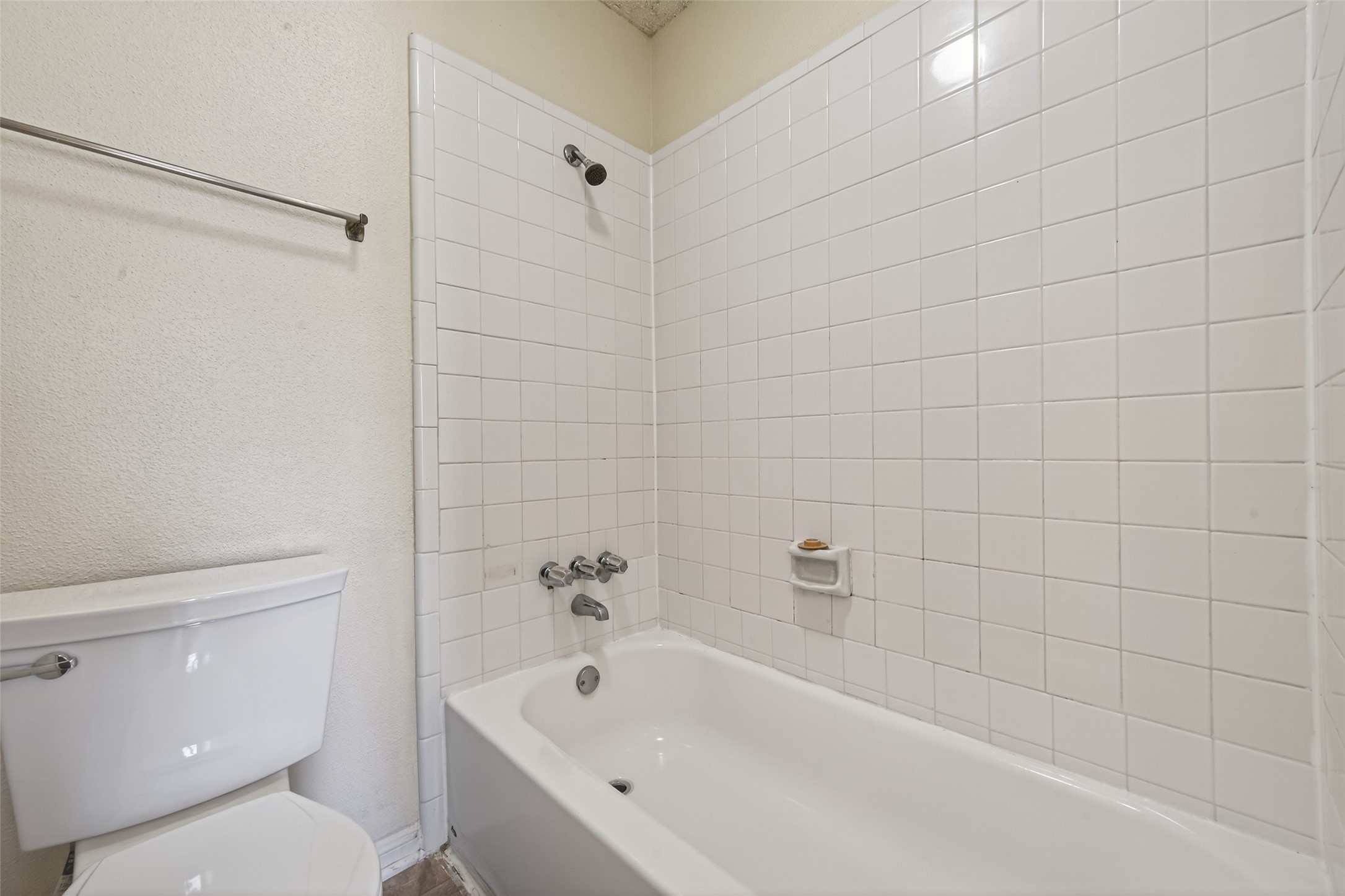 3100 Jeanetta Street, Unit 1004 Houston, TX 77063 - Photo 28 of 42 The full bathroom features a classic tile surround in the shower-and-tub combination, maintaining a bright and durable aesthetic.