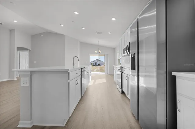 a large kitchen with stainless steel appliances lots of counter space and a sink