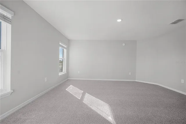 a spacious bathroom with double sink shower and two mirror