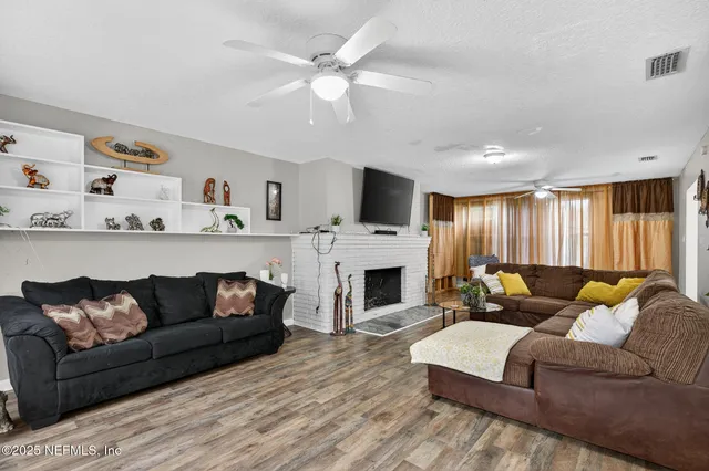 a living room with furniture a fireplace and a flat screen tv