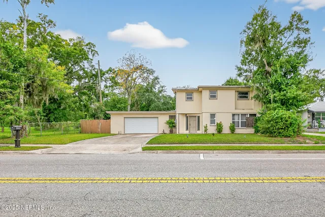a white house with a yard and plants