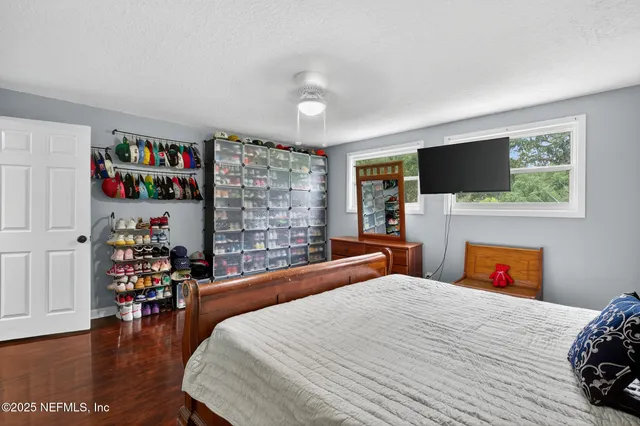 a bedroom with a bed and dresser with mirror