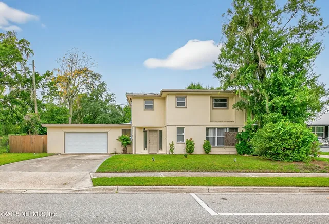 a front view of a house with a yard and a garage