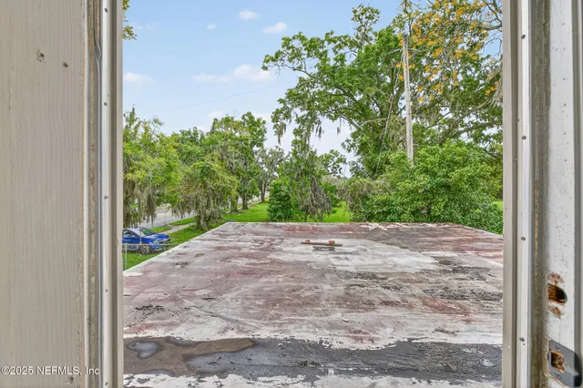 a view of a chair and table in backyard of the house