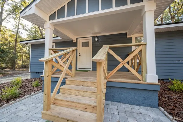a front view of a house with wooden stairs and a table