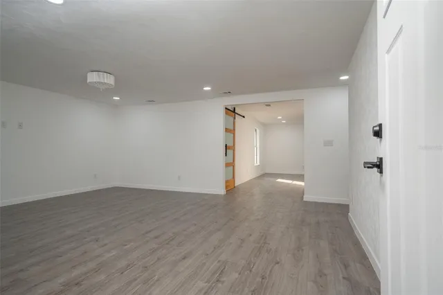 a view of an empty room with wooden floor
