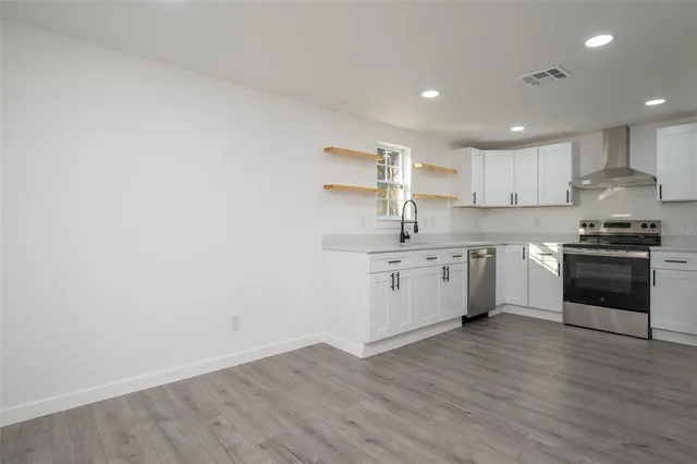 a kitchen with a sink a counter top space stainless steel appliances and cabinets
