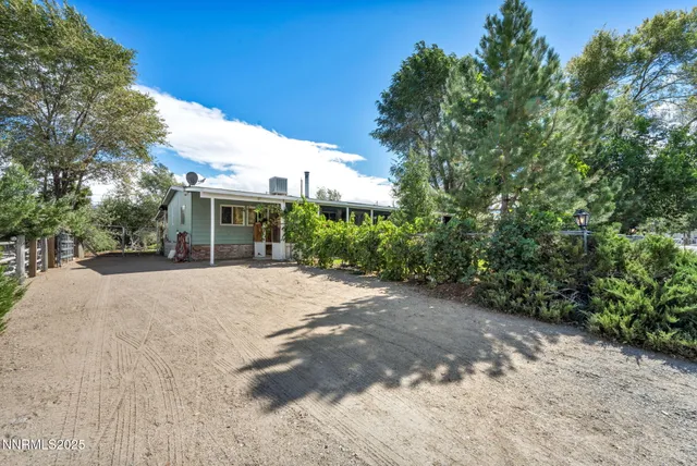 a view of a house with a yard and potted plants