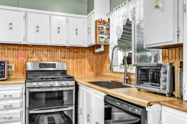 a kitchen with stainless steel appliances granite countertop a stove oven and a refrigerator with white cabinets