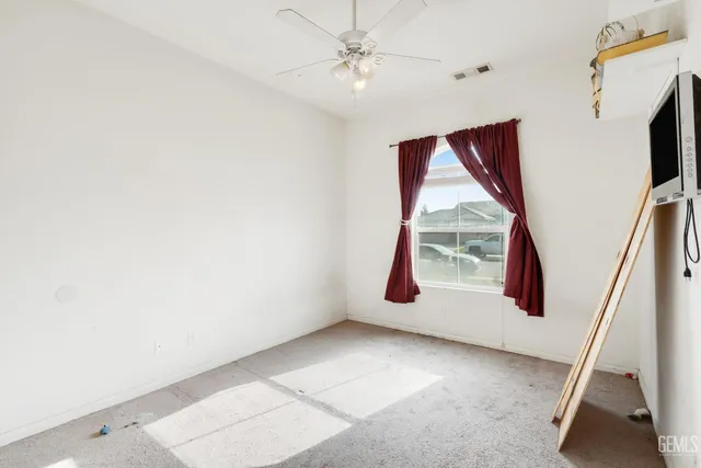 a view of a livingroom with wooden floor and a ceiling fan
