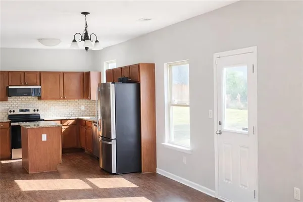 a kitchen with stainless steel appliances granite countertop a refrigerator and a stove top oven