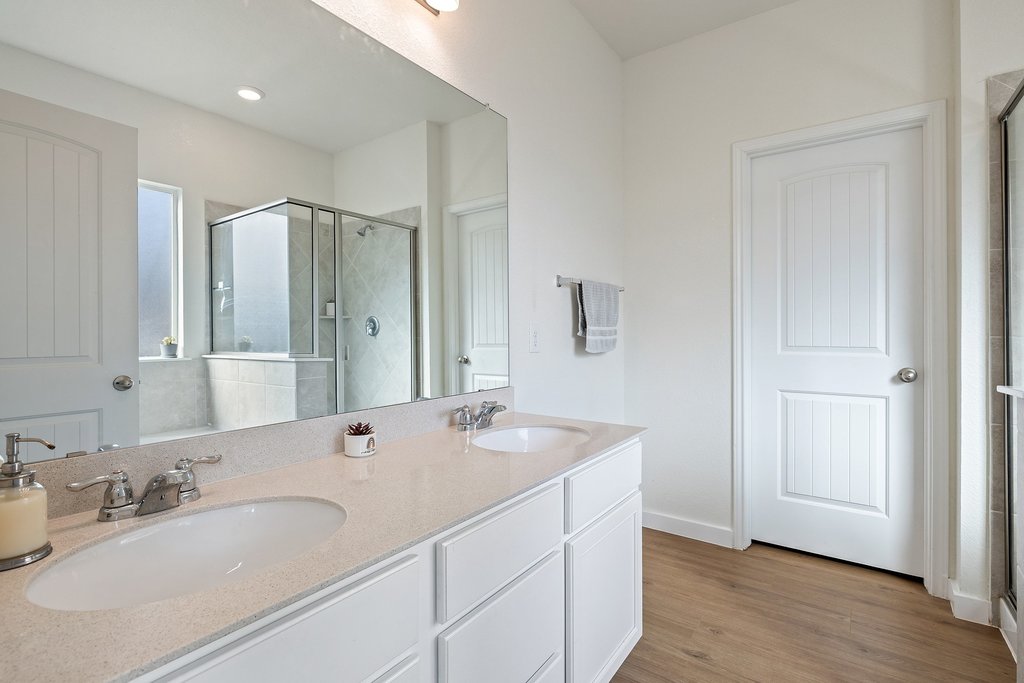 1926 Dragonfly Loop Bastrop, TX 78602 - Photo 13 of 33 a bathroom with double vanity sinks and a mirror