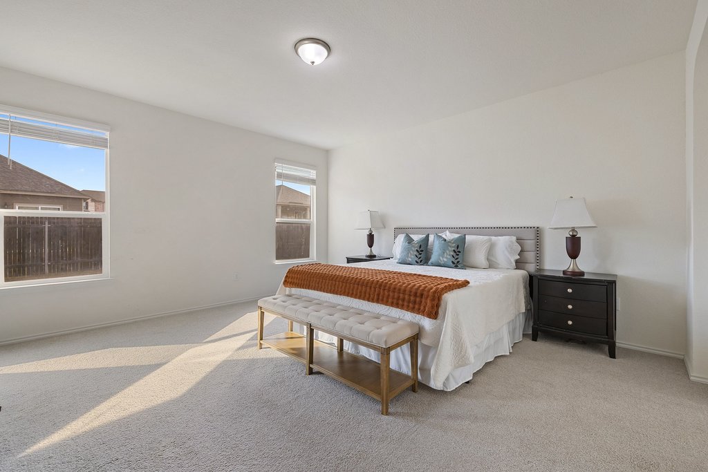 1926 Dragonfly Loop Bastrop, TX 78602 - Photo 15 of 32 a spacious bedroom with a bed and a window