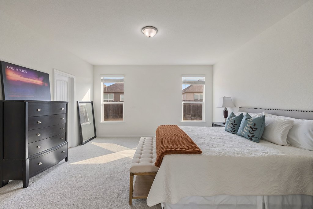 1926 Dragonfly Loop Bastrop, TX 78602 - Photo 16 of 32 a bedroom with a large bed and a window