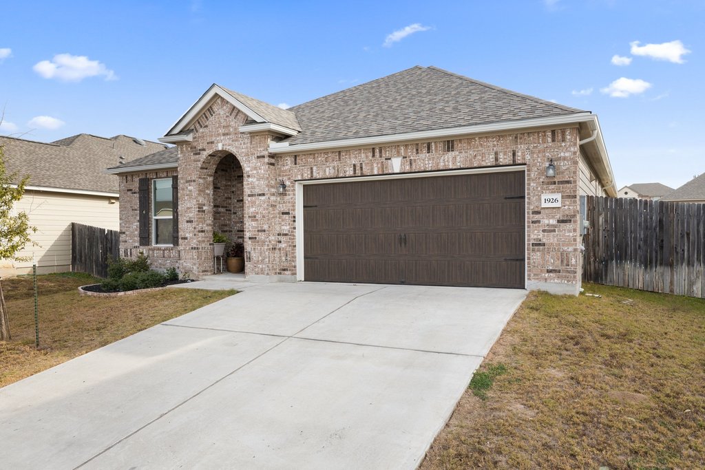 1926 Dragonfly Loop Bastrop, TX 78602 - Photo 2 of 32 a front view of a house with a yard and garage