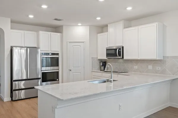 a kitchen with sink and white cabinets