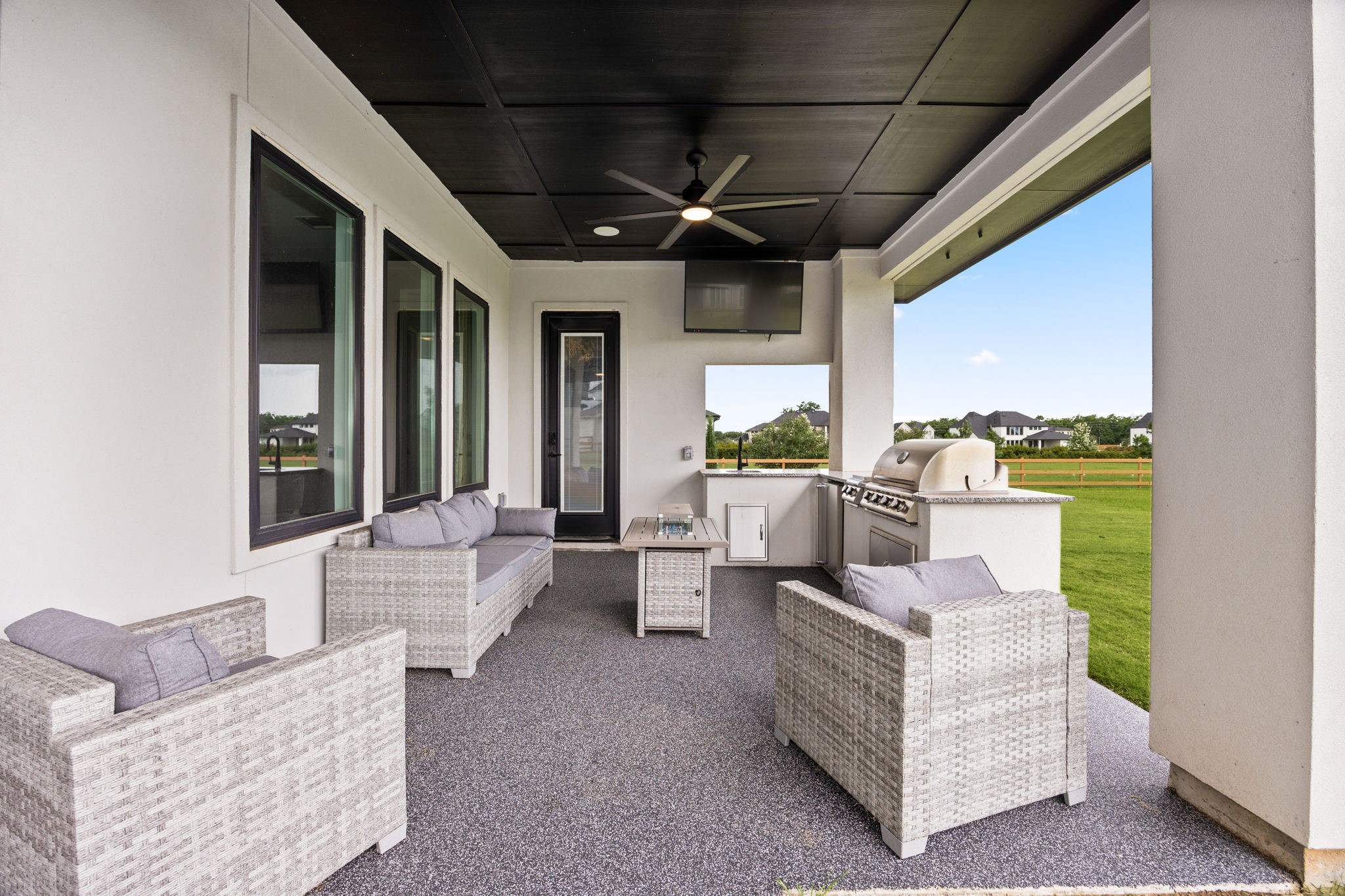 29419 Cir S Rnch Trail Fulshear, TX 77406 - Photo 32 of 45 The custom covered patio is plumbed for gas and serves as an exceptional outdoor living space, complete with a dark plank ceiling, a cooling fan, and a sophisticated integrated grill station.