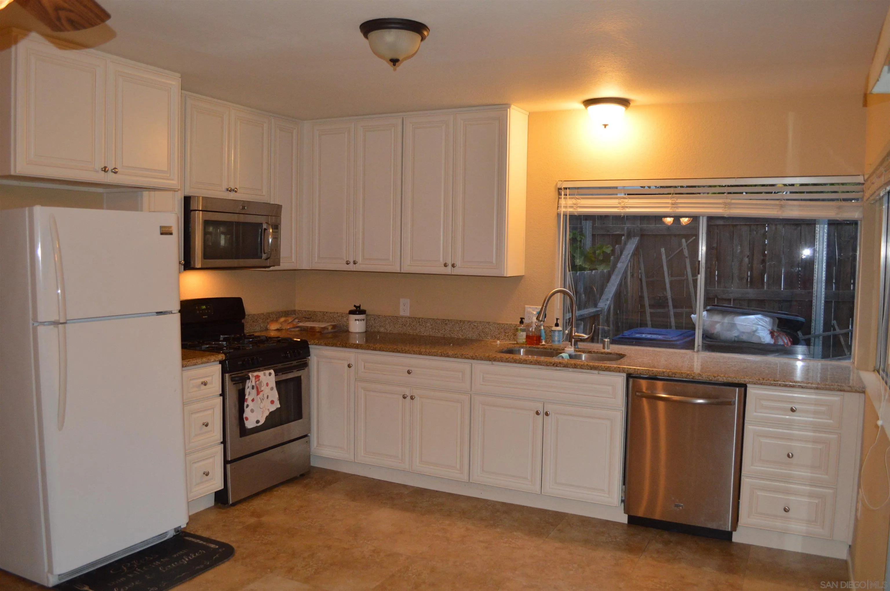 13353 Sutter Mill Road Poway, CA 92064 - Photo 6 of 14 a kitchen with stainless steel appliances granite countertop a stove a sink and a refrigerator