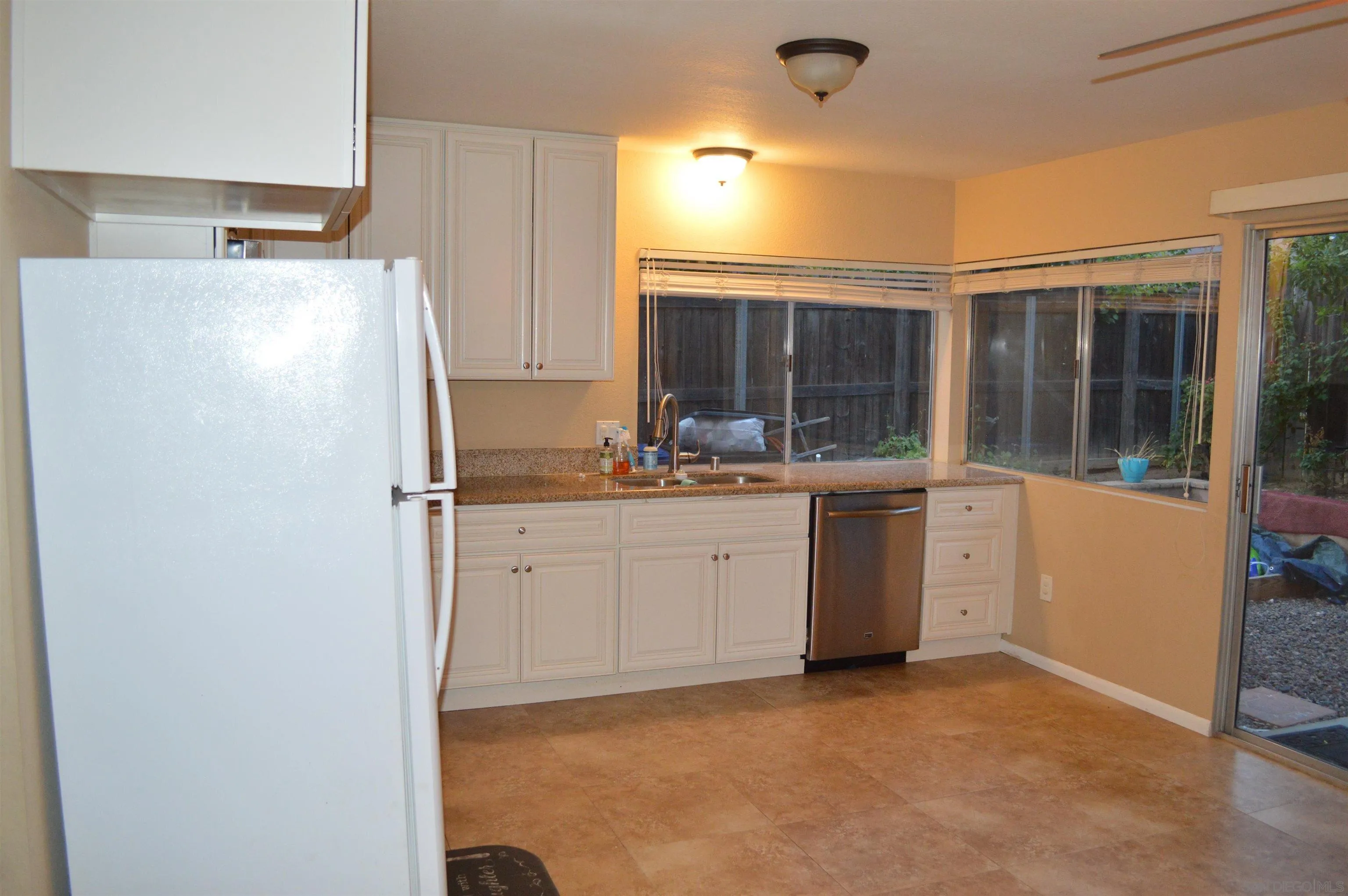 13353 Sutter Mill Road Poway, CA 92064 - Photo 7 of 14 a kitchen with white cabinets and white appliances