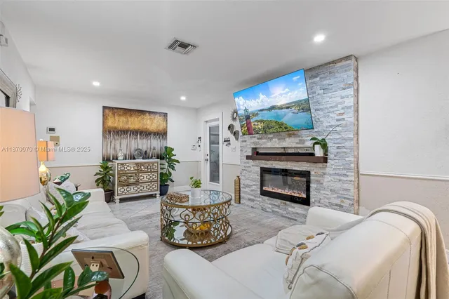 a living room with furniture a fireplace and a flat screen tv