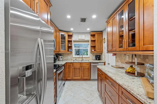 a kitchen with stainless steel appliances granite countertop a sink stove and refrigerator