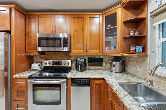 a kitchen with stainless steel appliances granite countertop a sink stove and cabinets