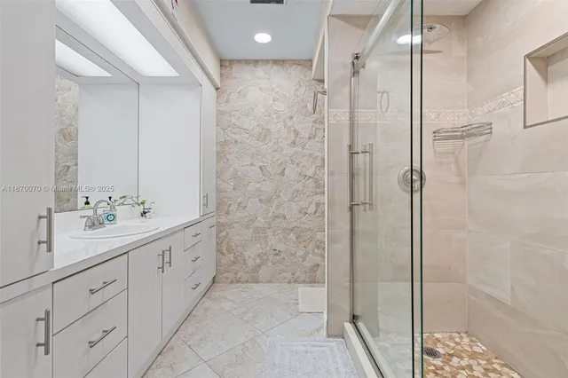 a bathroom with a shower sink and mirror